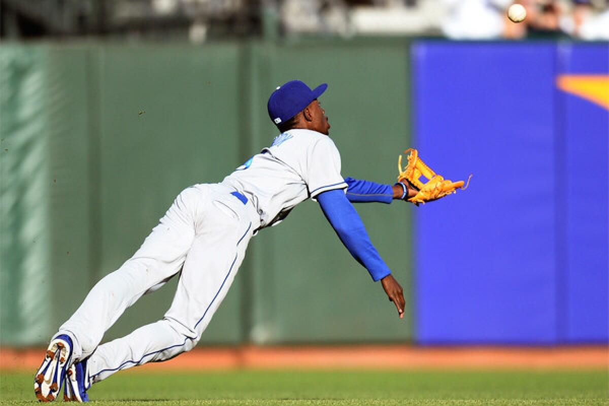 Dodgers shortstop Dee Gordon dives for a short fly ball that goes for a double off the bat of San Francisco's Angel Pagan on Friday night.