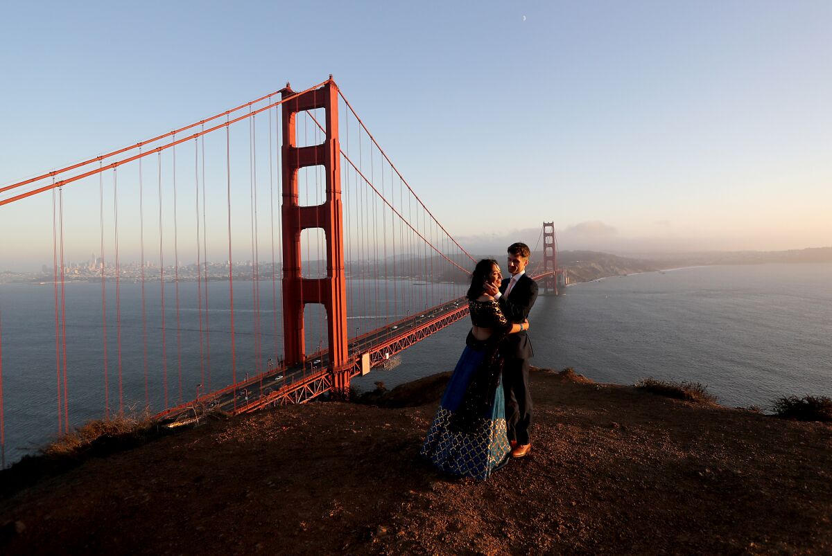 Newlyweds Tulika Jha and Mike Borden take in the sunset beside the Golden Gate Bridge.