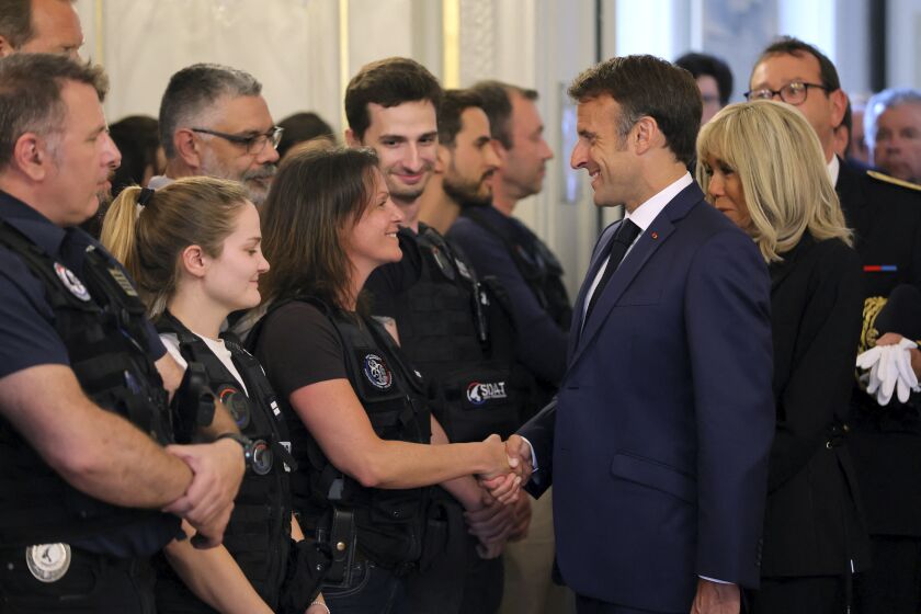 French President Emmanuel Macron and his wife Brigitte Macron, right, meet rescue forces, in Annecy, French Alps, Friday, June 9, 2023. A man with a knife stabbed four young children at a lakeside park in the French Alps on Thursday June 8, 2023, assaulting at least one in a stroller repeatedly. Authorities said the children, between 22 months and 3 years old, suffered life-threatening injuries, and two adults were also wounded. (Denis Balibouse/Pool via AP)