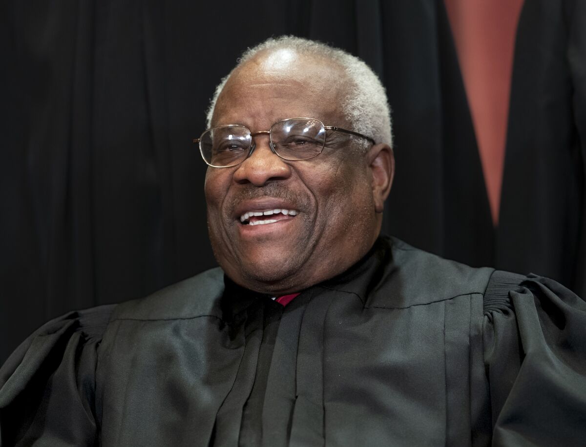 FIILE - In this Nov. 30, 2018, file photo, Supreme Court Associate Justice Clarence Thomas, appointed by President George H. W. Bush, sits with fellow Supreme Court justices for a group portrait at the Supreme Court Building in Washington. Thomas has never been afraid to turn right when his colleagues turn left, or in any direction really as long as there’s a place to plug in his 40-foot refitted tour bus. (AP Photo/J. Scott Applewhite, File)