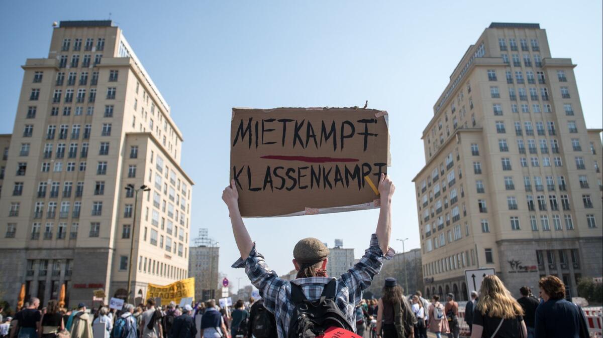 A protester holds up a sign that says "Rent Fight, Class Fight" at a demonstration against rising apartment rents in Berlin.