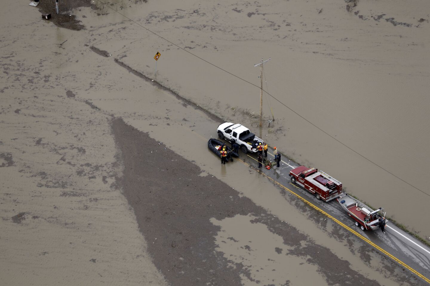 Rescue personnel stage operations on a flooded road in West Alton, Mo.