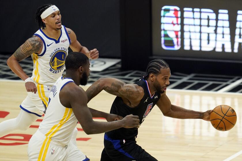Los Angeles Clippers forward Kawhi Leonard, right, dribbles past Golden State Warriors forward Eric Paschall, bottom left, and Damion Lee (1) during the second half of an NBA basketball game Thursday, March 11, 2021, in Los Angeles. (AP Photo/Marcio Jose Sanchez)