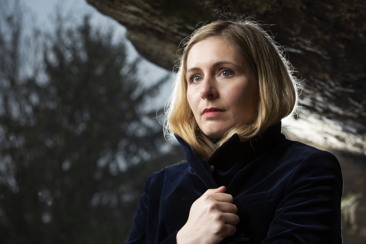 Eleanor Catton stands in a coat outdoors.