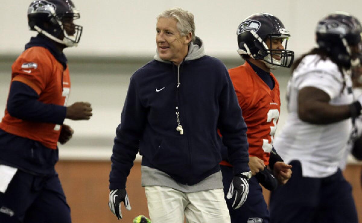 Seattle Seahawks Coach Pete Carroll watches as players warm up during a team practice session Thursday. Carroll may be the second-oldest coach in the NFL, but he doesn't act like it.