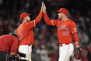 Anthony Rendon, left, and Mike Trout high-five each other after the Angels' win over the Red Sox