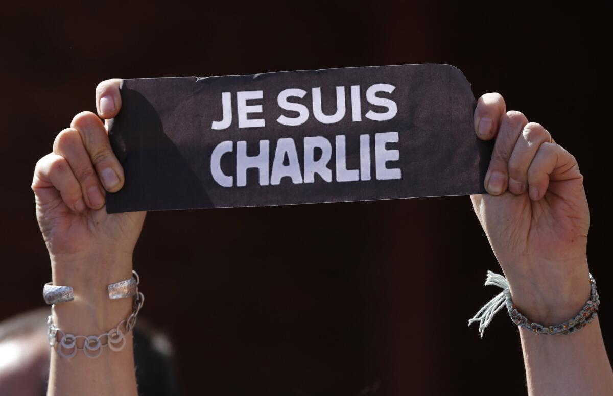 A person holds a sign that reads in French "I am Charlie" during a gathering in solidarity with the victims of recent attacks in France at the French Alliance community center in Quito, Ecuador.