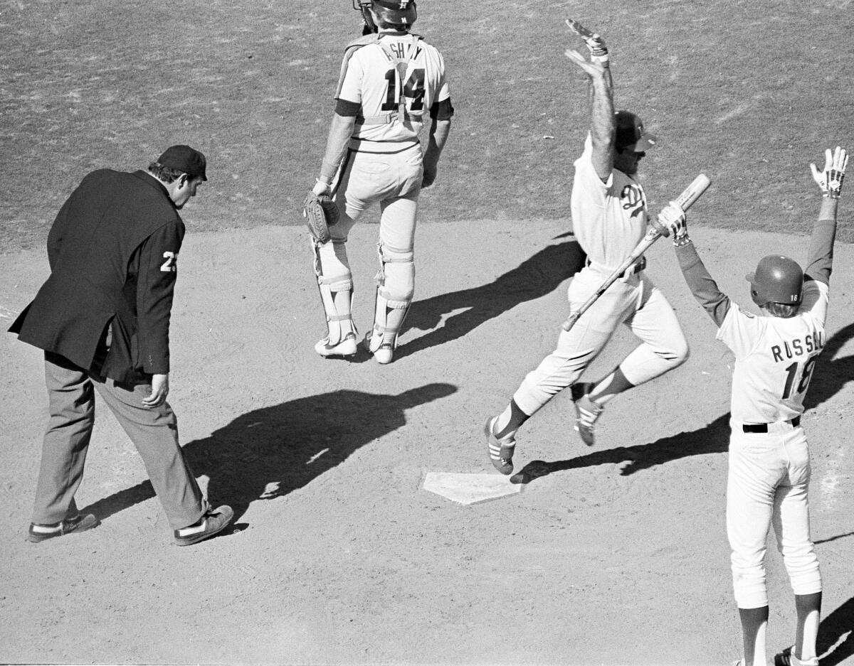 Steve Garvey scores in front of Dodgers teammate Bill Russell.