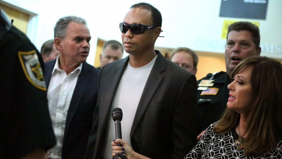 Golfer Tiger Woods, center, leaves the North County Courthouse in Palm Beach Gardens, Fla., Friday Oct. 27, 2017, after pleading guilty to a reckless driving charge.