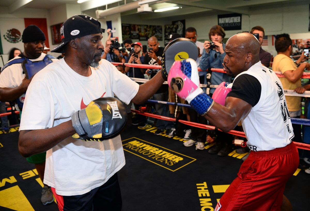 Boxer Floyd Mayweather Jr., right, works out with his trainer and uncle Roger Mayweather at Mayweather Boxing Club in Las Vegas in April 2014.