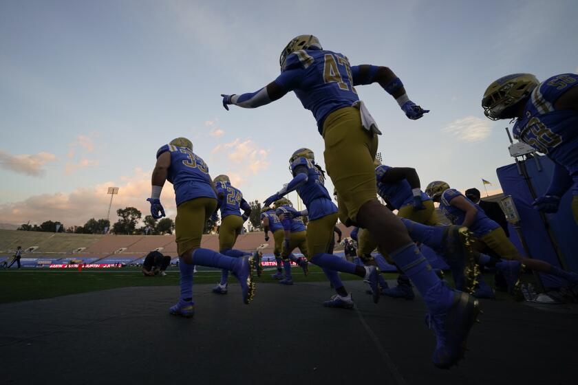 UCLA players enter the Rose Bowl before their game against rival USC on Dec. 12, 2020.