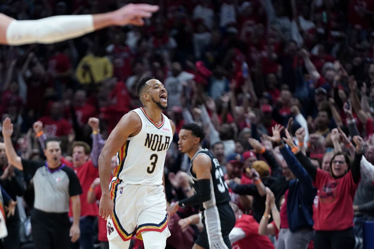 New Orleans Pelicans guard CJ McCollum (3) reacts with the crowd after scoring a 3-point basket in the first half of an NBA play-in basketball game against the San Antonio Spurs in New Orleans, Wednesday, April 13, 2022. (AP Photo/Gerald Herbert)