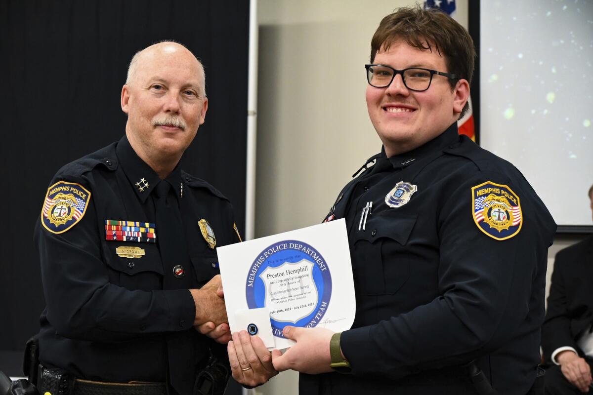 An assistant police chief, left, gives a certificate to another police officer. 