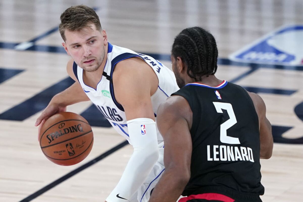 The Mavericks' Luka Doncic is defended by the Clippers' Kawhi Leonard.