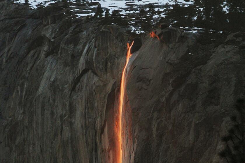 FILE - In this Feb. 16, 2010, file photo, a shaft of sunlight creates a glow near Horsetail Fall, in Yosemite National Park, Calif. Adventurers hoping to see Yosemite National Park's annual "firefall" will need reservations. At least 50 permits will be issued for each day between Feb. 12 and Feb. 26. The annual event is known to attract over 1,000 sightseers a year. (Eric Paul Zamora/The Fresno Bee via AP, File)