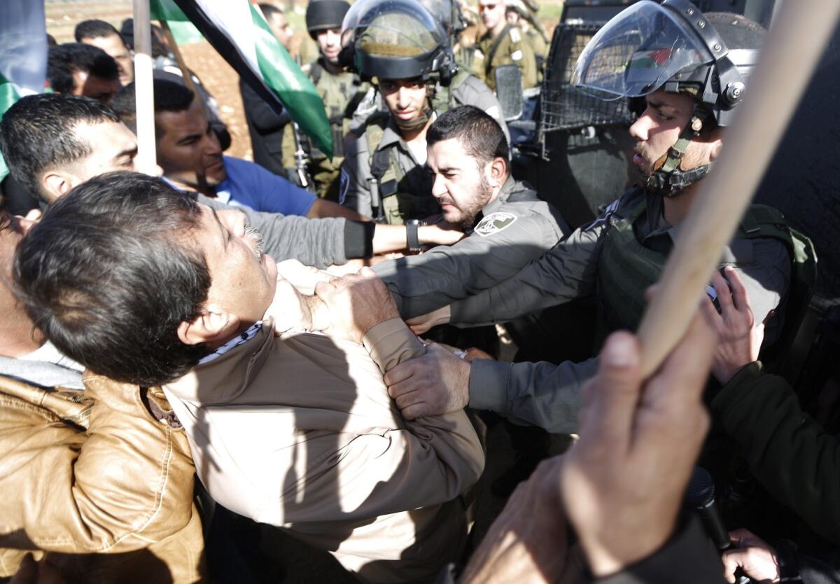 An Israeli border guard grabs Palestinian official Ziad Abu Ein during a demonstration in the village of Turmus Ayya near Ramallah, West Bank, on Dec. 10.