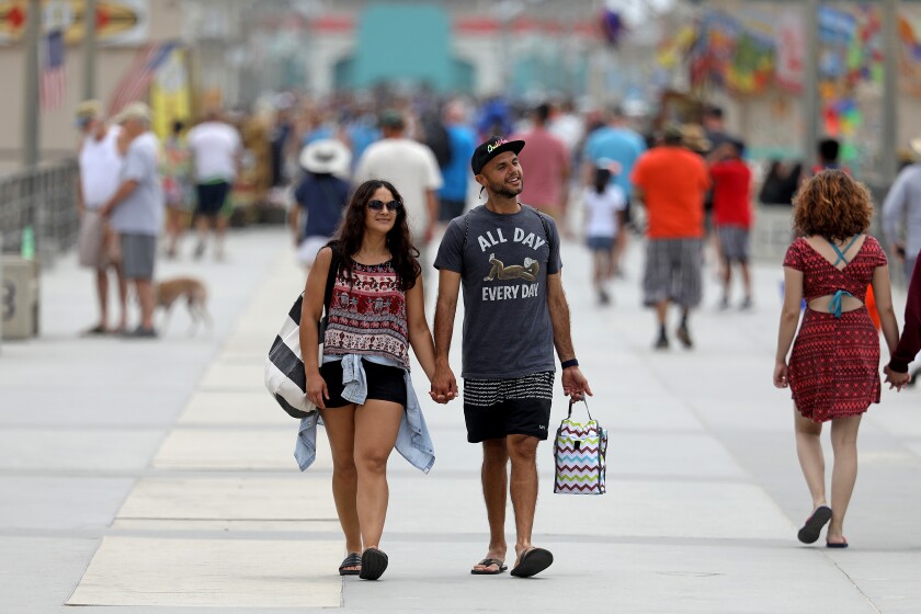 People stroll along the Huntington Beach pier on June 15, the day most of California's COVID-19 restrictions were lifted.