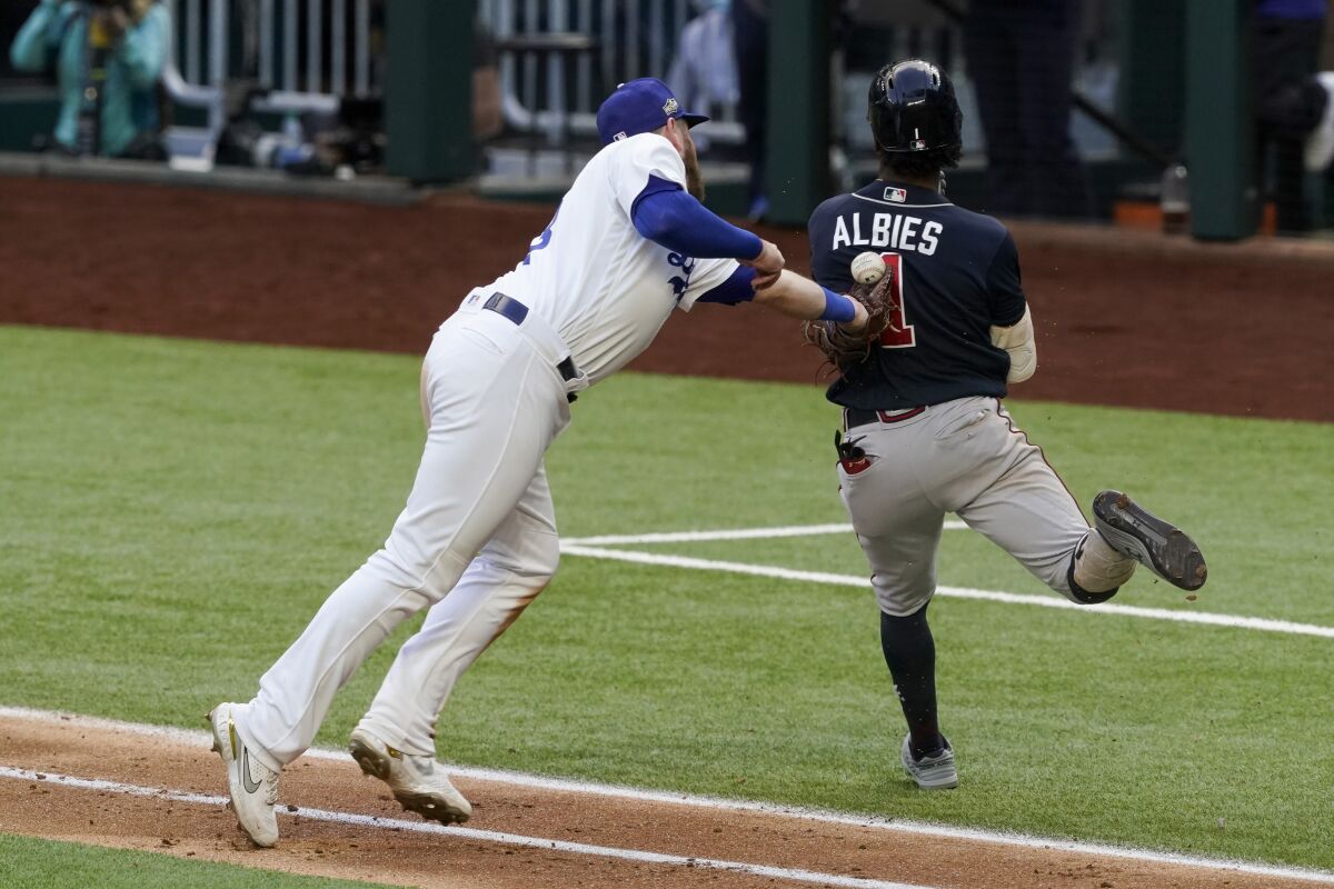 Dodgers first baseman Max Muncy attempts to tag out Atlanta Braves second baseman Ozzie Albies during the sixth inning.
