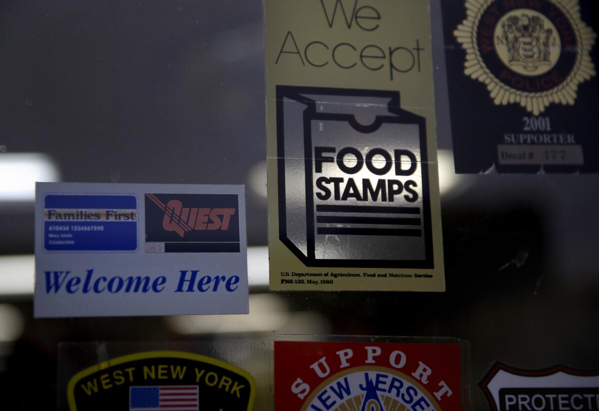 A supermarket displays stickers indicating it accepts food stamps