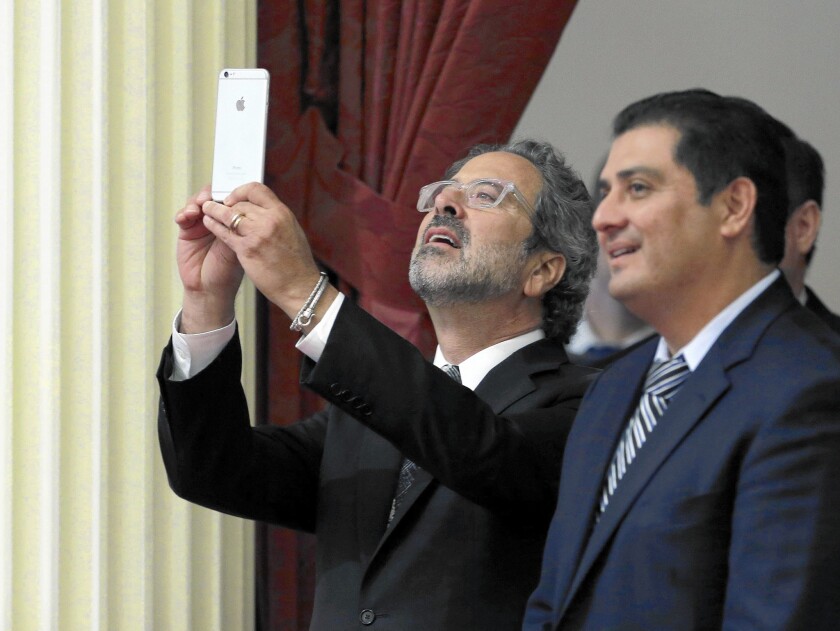 Assemblyman Richard Bloom, left, with Sen. Ben Hueso, takes a picture of the votes being posted for his measure to phase out the use of microbeads in personal care products.