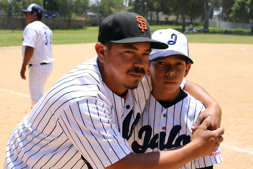 Luis Marquez who is currently living in Los Angeles, hasn't seen his son in three years, he hugs his son Carlos Marquez, who is visiting Los Angeles with his little league baseball team the "Jalos" from Jalostotitlan, Mexico, at Stevenson Park in Carson on Sunday, July 2, 2023. (Photo by James Carbone/ Los Angeles Times en Espanol)