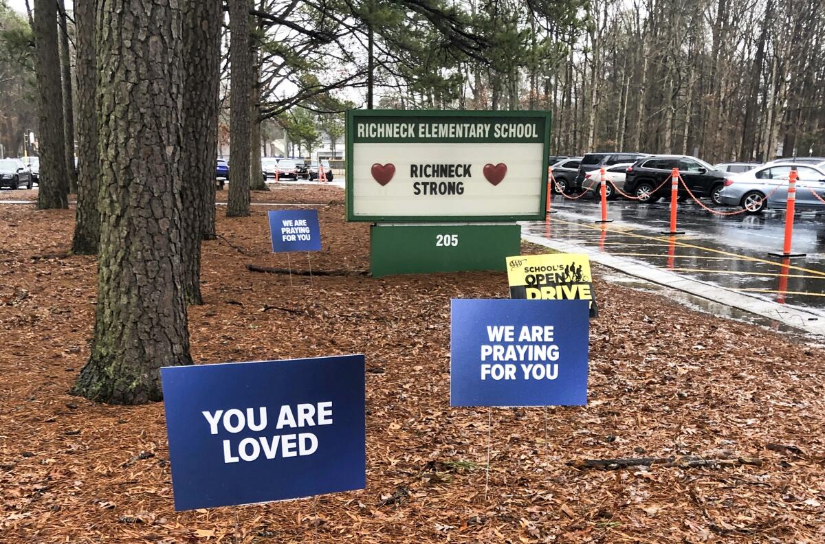 Signs expressing support for a teacher who was shot by a 6-year-old student