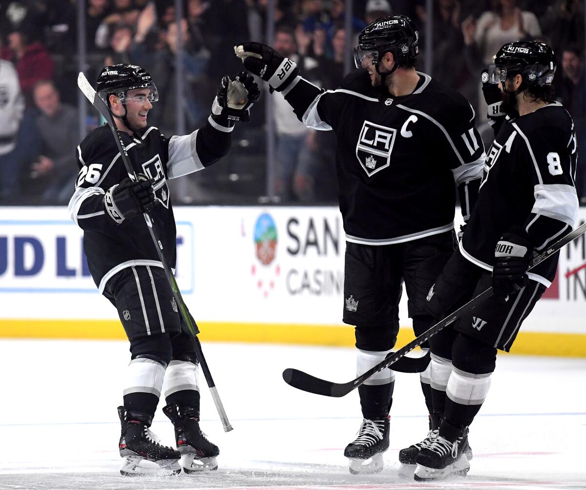 Kings rookie defenseman Sean Walker celebrates his empty goal with Anze Kopitar (11) and Drew Doughty (8) during the third period of a win Nov. 12 over the Wild.