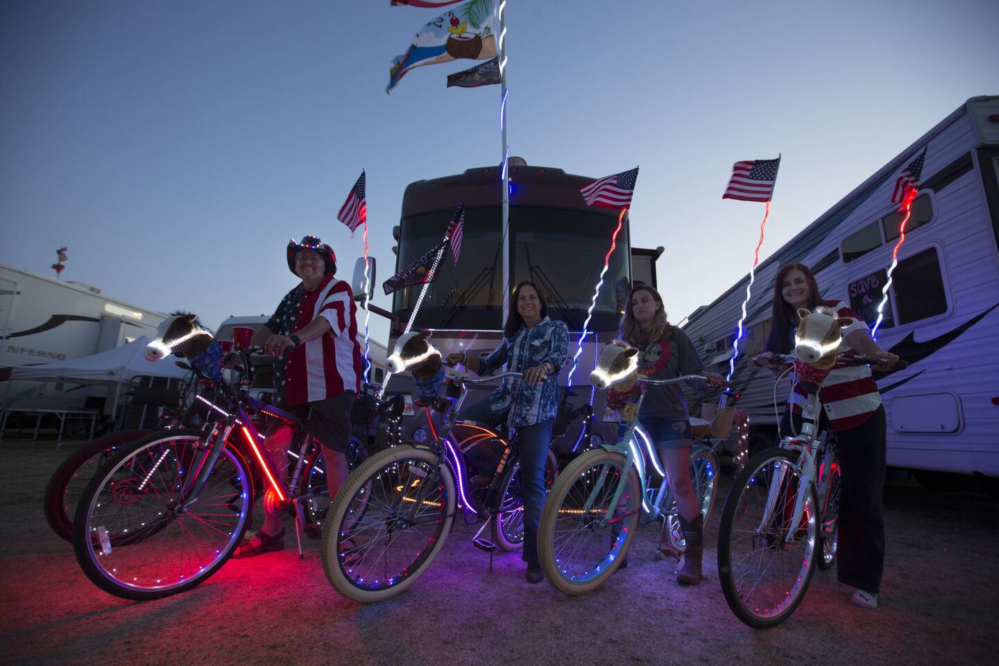 Country music fans, from left, Vito Pace, Linda Vogel, Cassidy Vogel, Michelle Pace, all of Calabasas, sport LED lights on their bikes at dusk in the RV Resort for the 10th anniversary of the Stagecoach Country Music Festival at the Empire Polo Club in Indio.