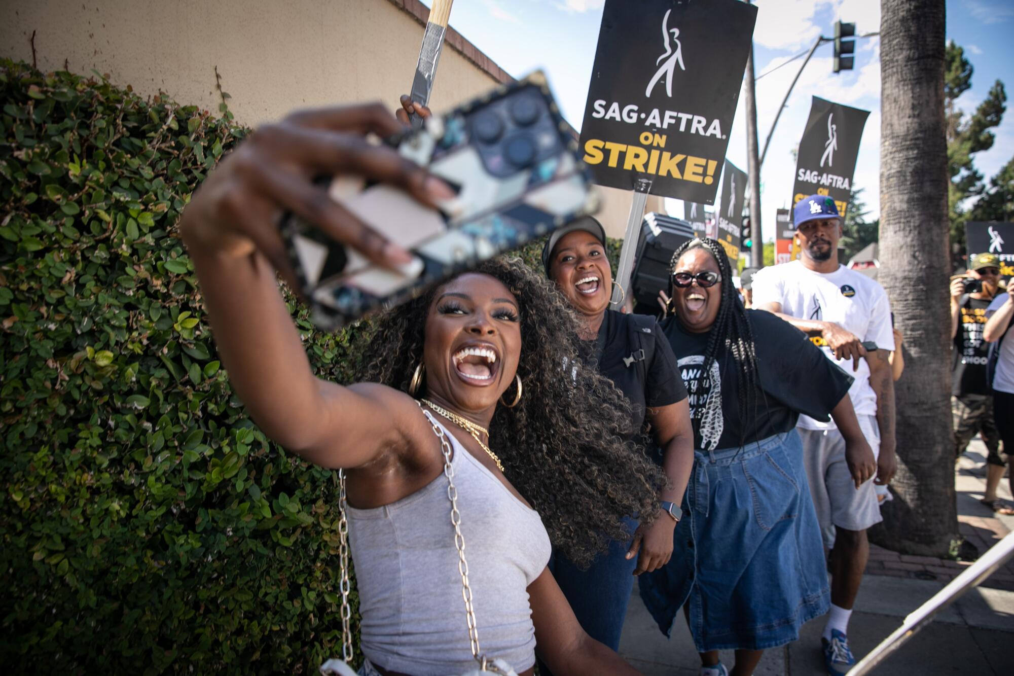 Three Black women take a selfie together on a picket line