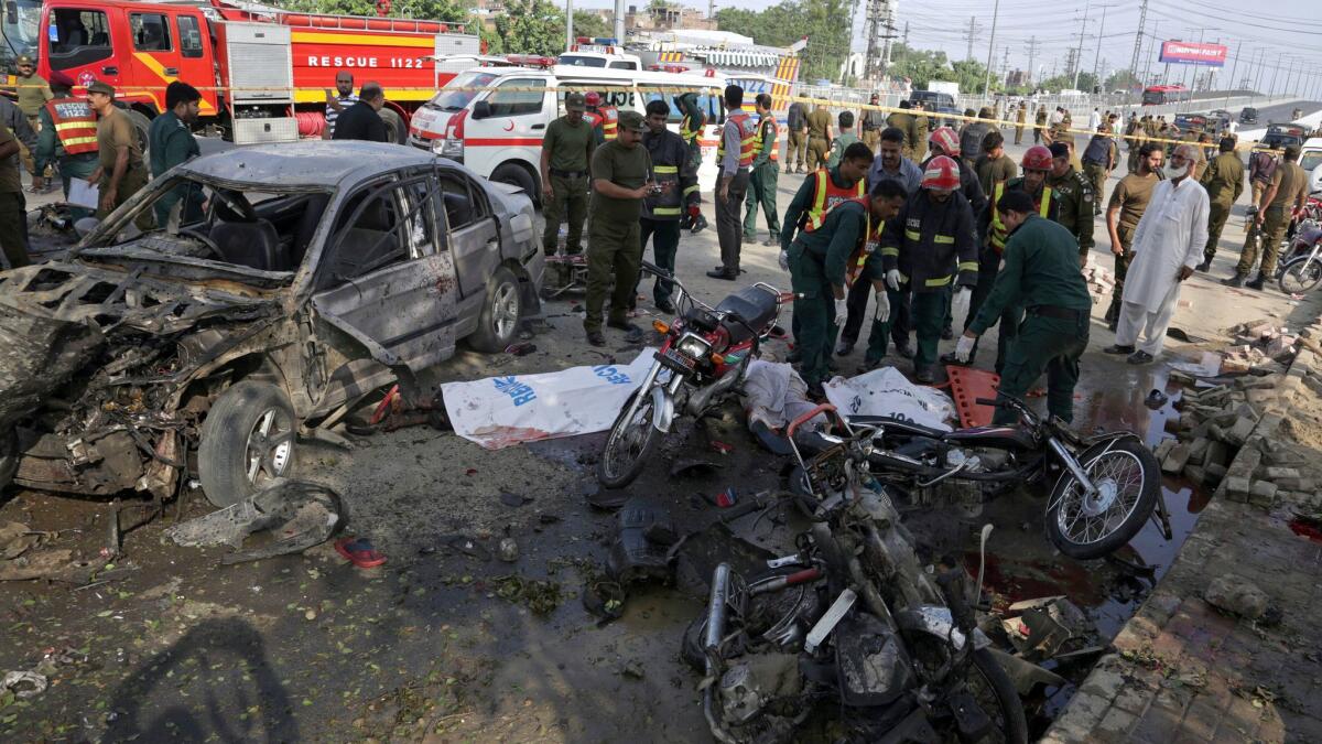 Pakistani rescue workers prepare to remove a body from the site of a bombing in the eastern city of Lahore, Pakistan, Monday, July 24, 2017.