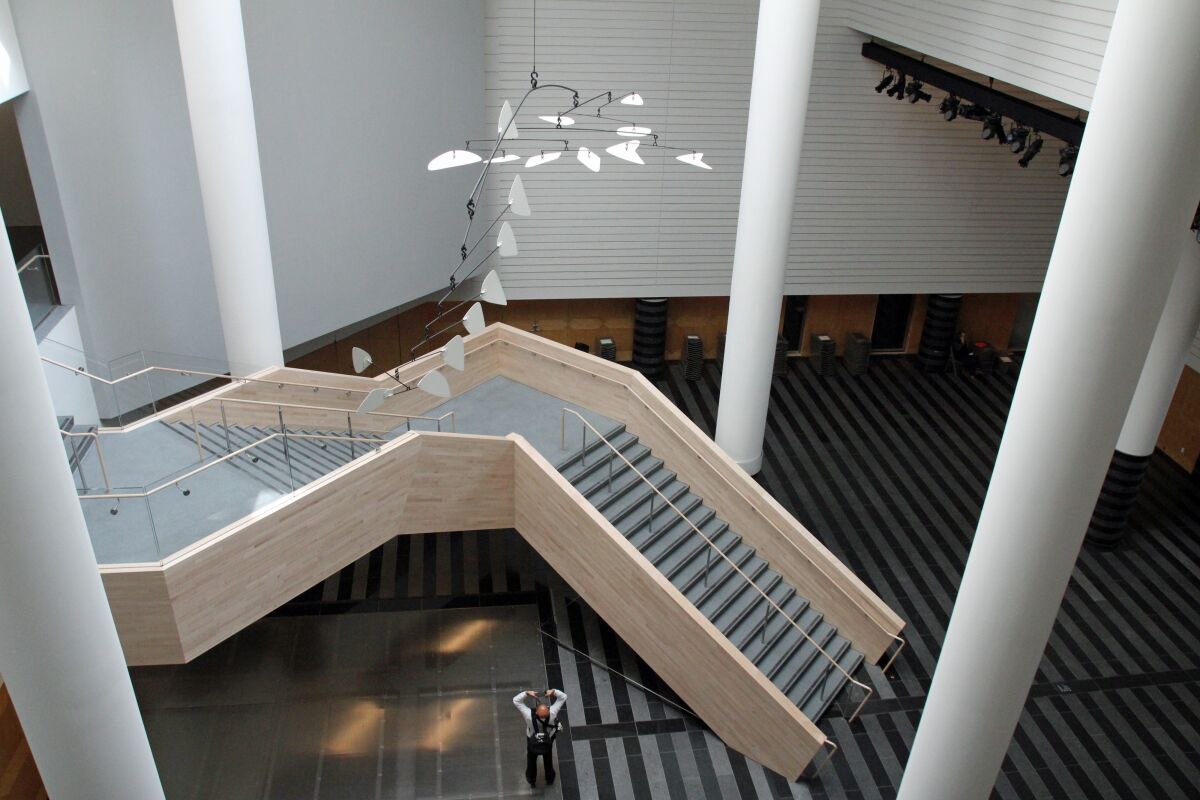 A staircase in SFMOMA's atrium, over which hangs a mobile by Alexander Calder.