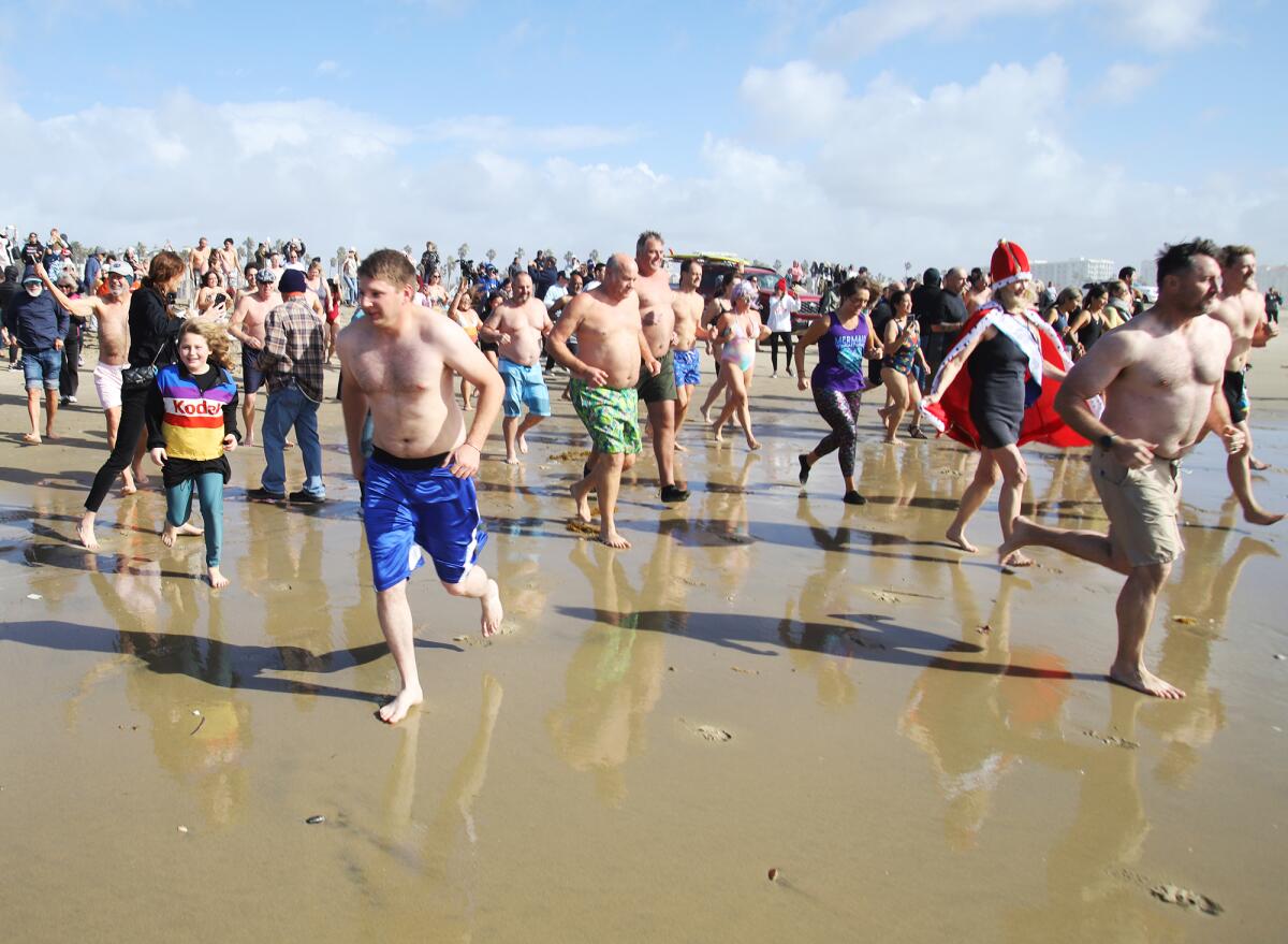 Hundreds of people run into the chilly Pacific Ocean as they took part in the Surf City Splash.