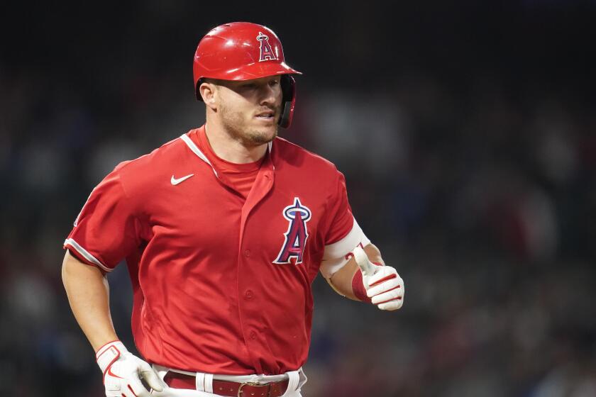Los Angeles Angels' Mike Trout (27) runs to first base during a spring training baseball game against the Los Angeles Dodgers in Anaheim, Calif., Monday, April 4, 2022. (AP Photo/Ashley Landis)