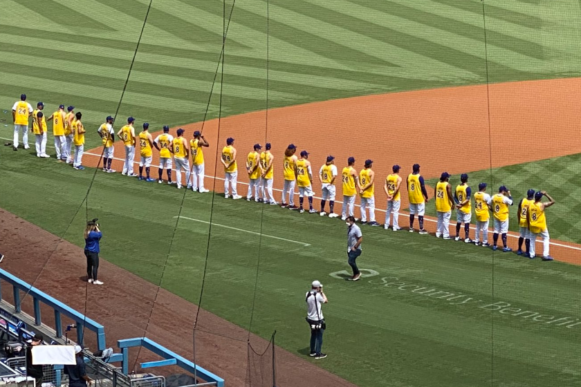 Dodgers players wear Kobe Bryant jerseys while lining up on the field before a game against the Colorado Rockies.