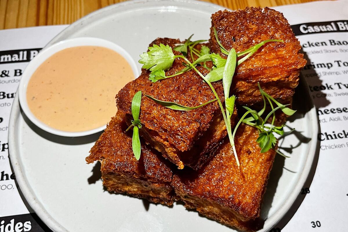 A plate of piled, deep-fried shrimp toast with dipping sauce at Jilli restaurant in Koreatown