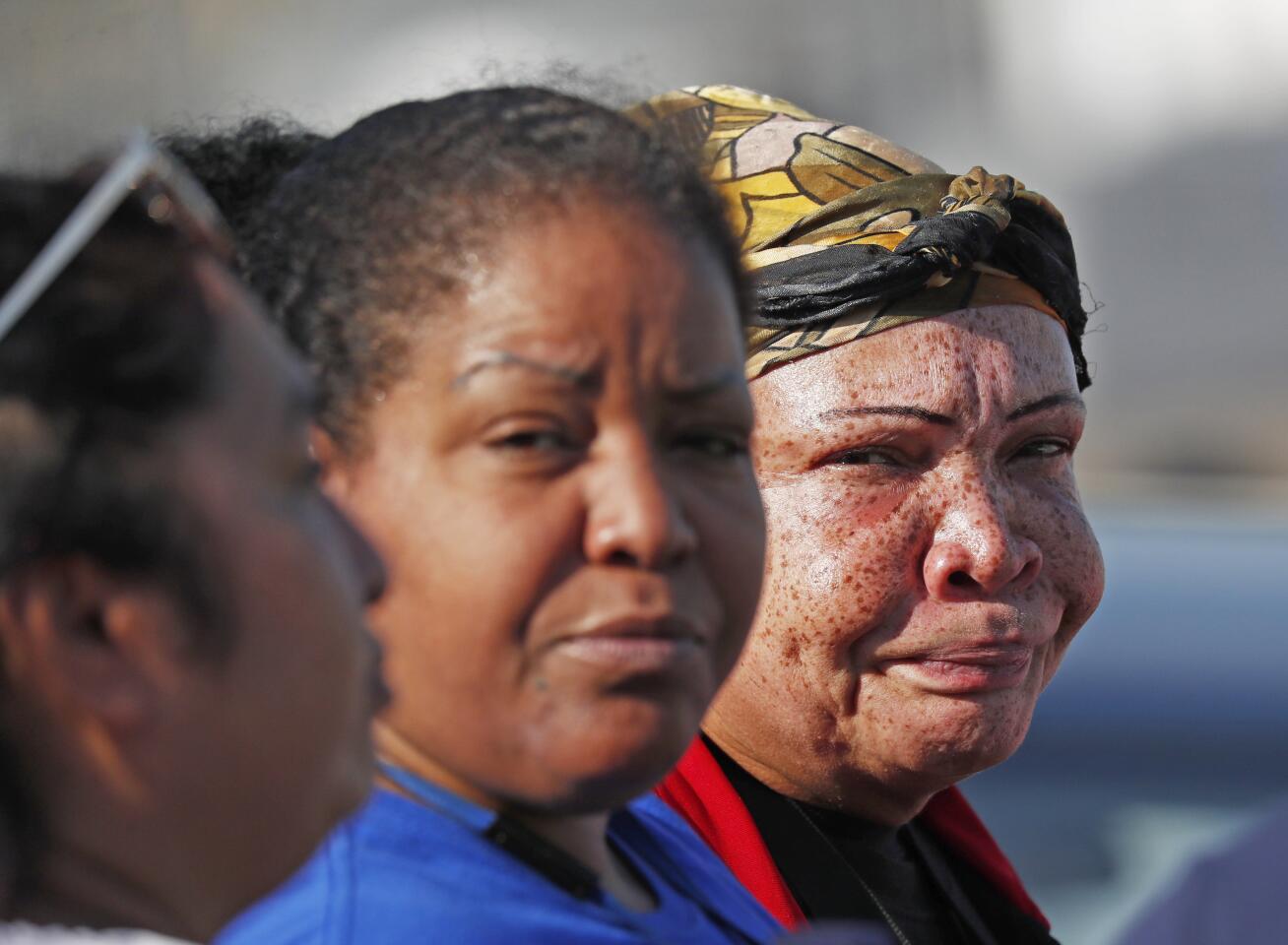 Friends, co-workers and family talk among themselves as they watch U.S. immigration officials raid the Koch Foods Inc. plant in Morton, Miss.