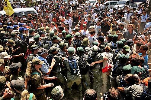 Israeli police struggle with protesters who were trying to prevent them from entering the settlement of Neve Dekalim.