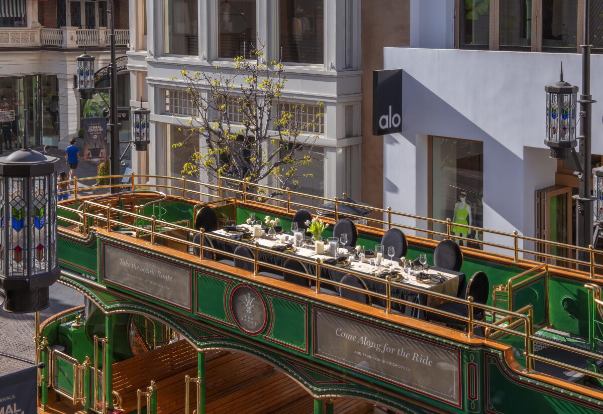 A long table with place settings sits on the top deck of a trolley.