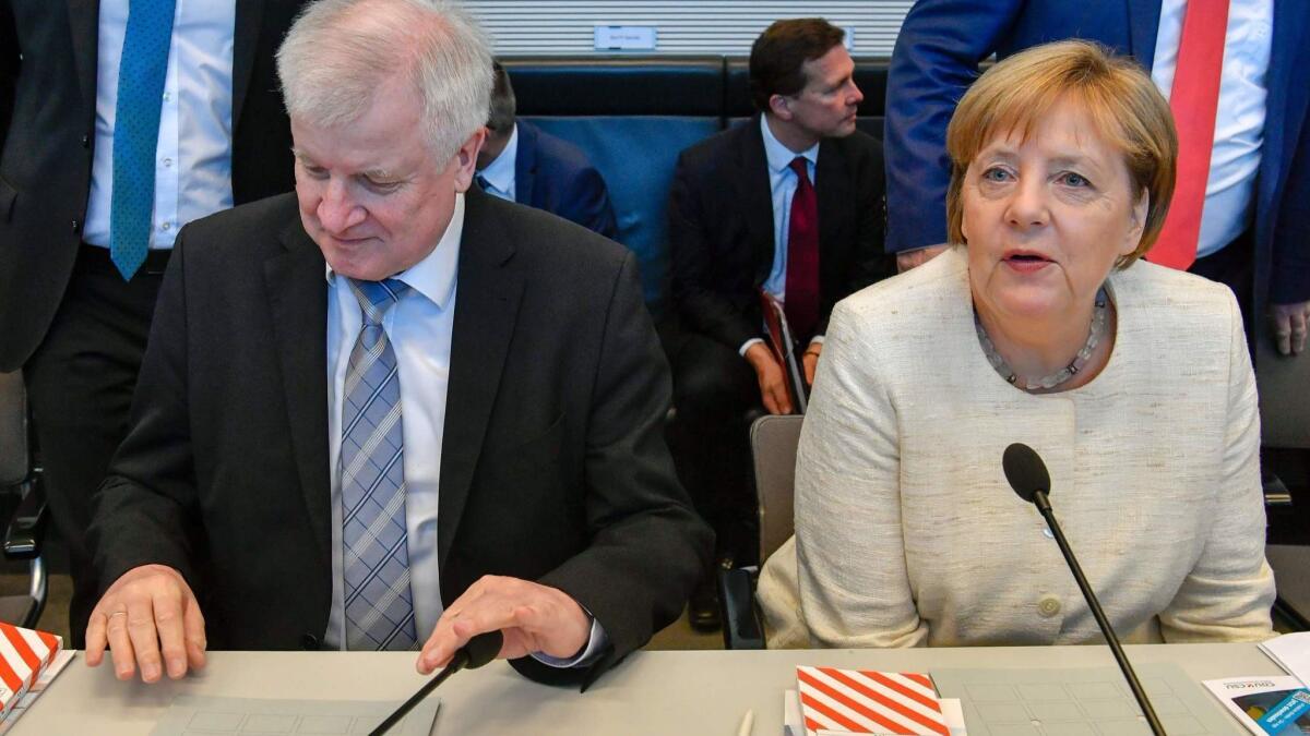 German Chancellor Angela Merkel and German Interior Minister Horst Seehofer attend a meeting in Berlin on Tuesday.