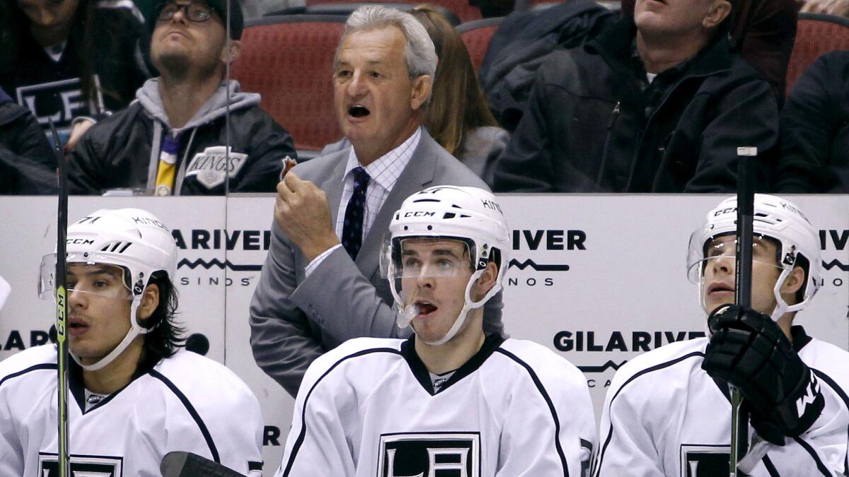 Kings Coach Darryl Sutter had some motivational words for captain Dustin Brown, bottom right, before a 4-3 overtime victory over the Coyotes on Saturday.