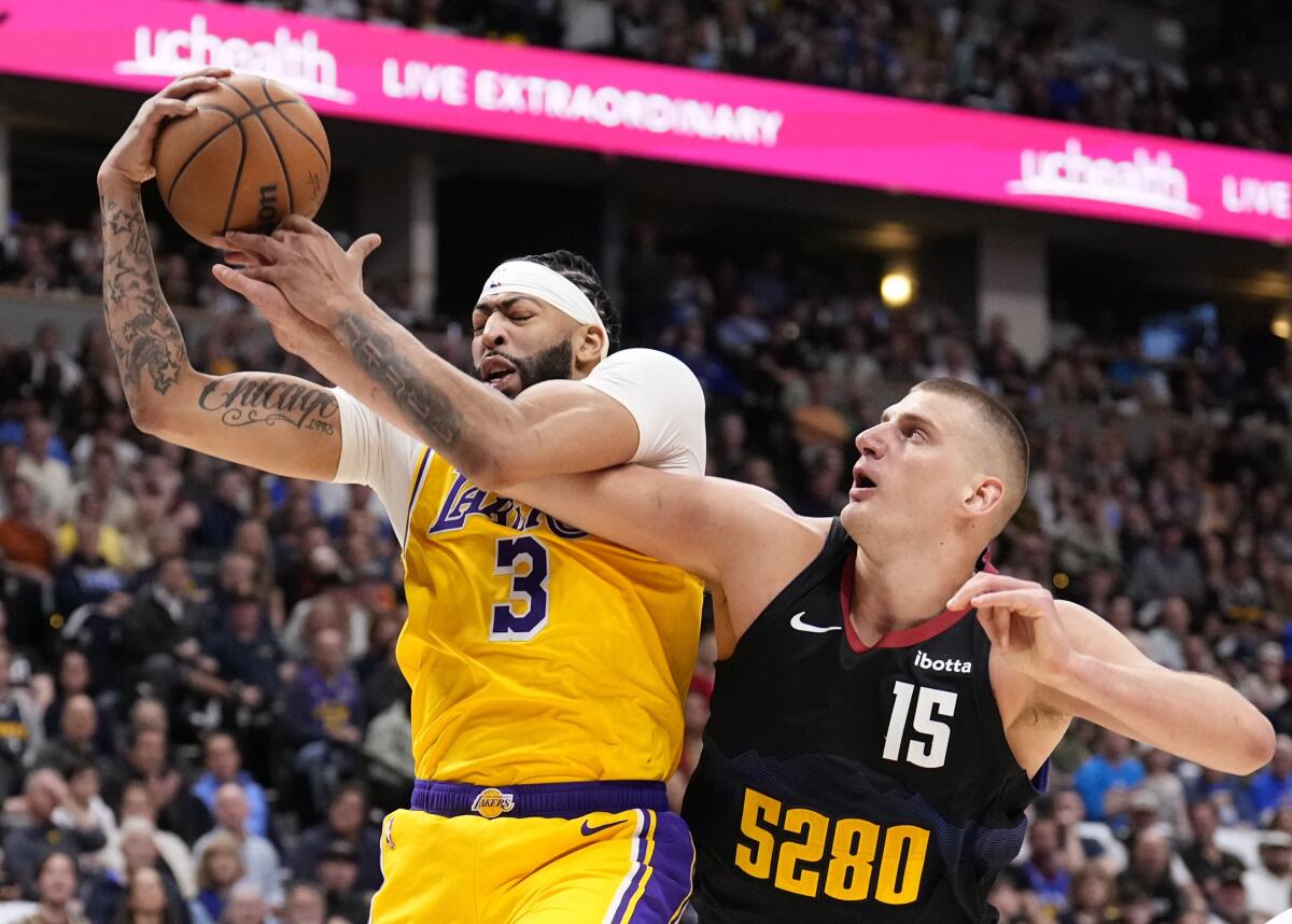 Denver Nuggets center Nikola Jokic tries to take the basketball from Los Angeles Lakers forward Anthony Davis.