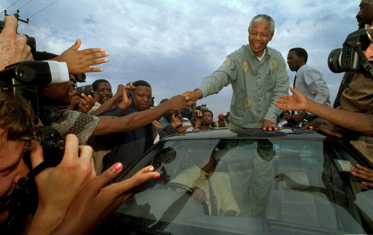 Nelson Mandela is swarmed in Lamontville township during his presidential bid in 1994, when South Africa held its first multiracial democratic elections and the ANC swept to power.
