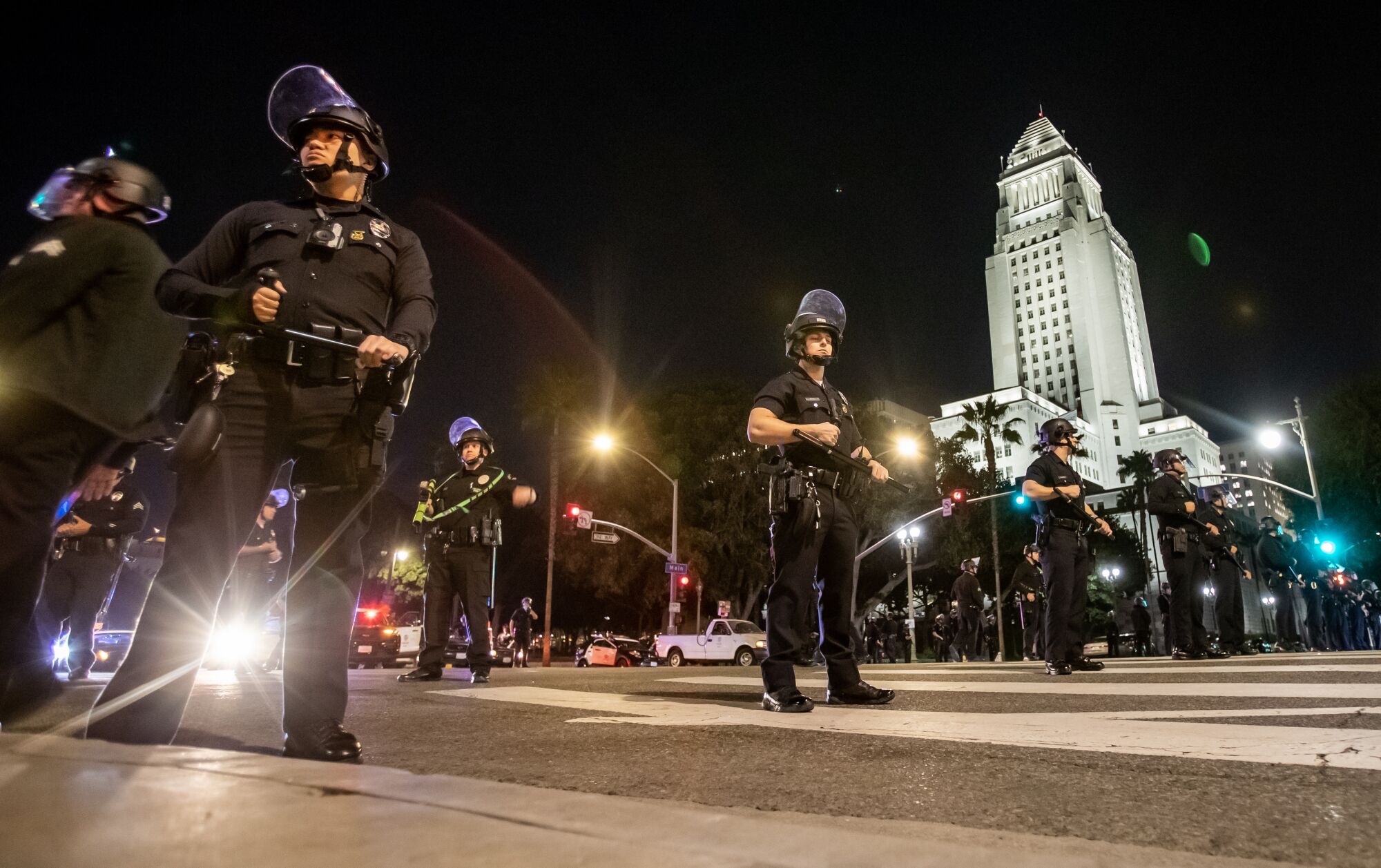 LAPD protects an intersection with City Hall building in background.   