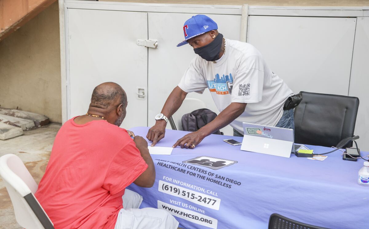  Homeless case manager Michael Jones helps member Curtis Cormier with paperwork at the C2C clubhouse.