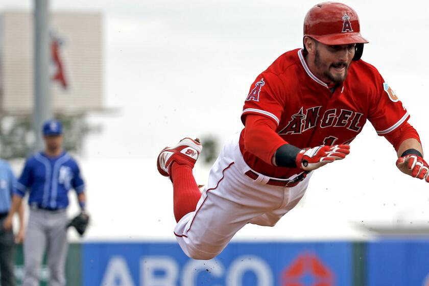 Angels second baseman Johnny Giavotella makes a head-first dive for a triple during the second inning of a spring training game against the Royals on Sunday.