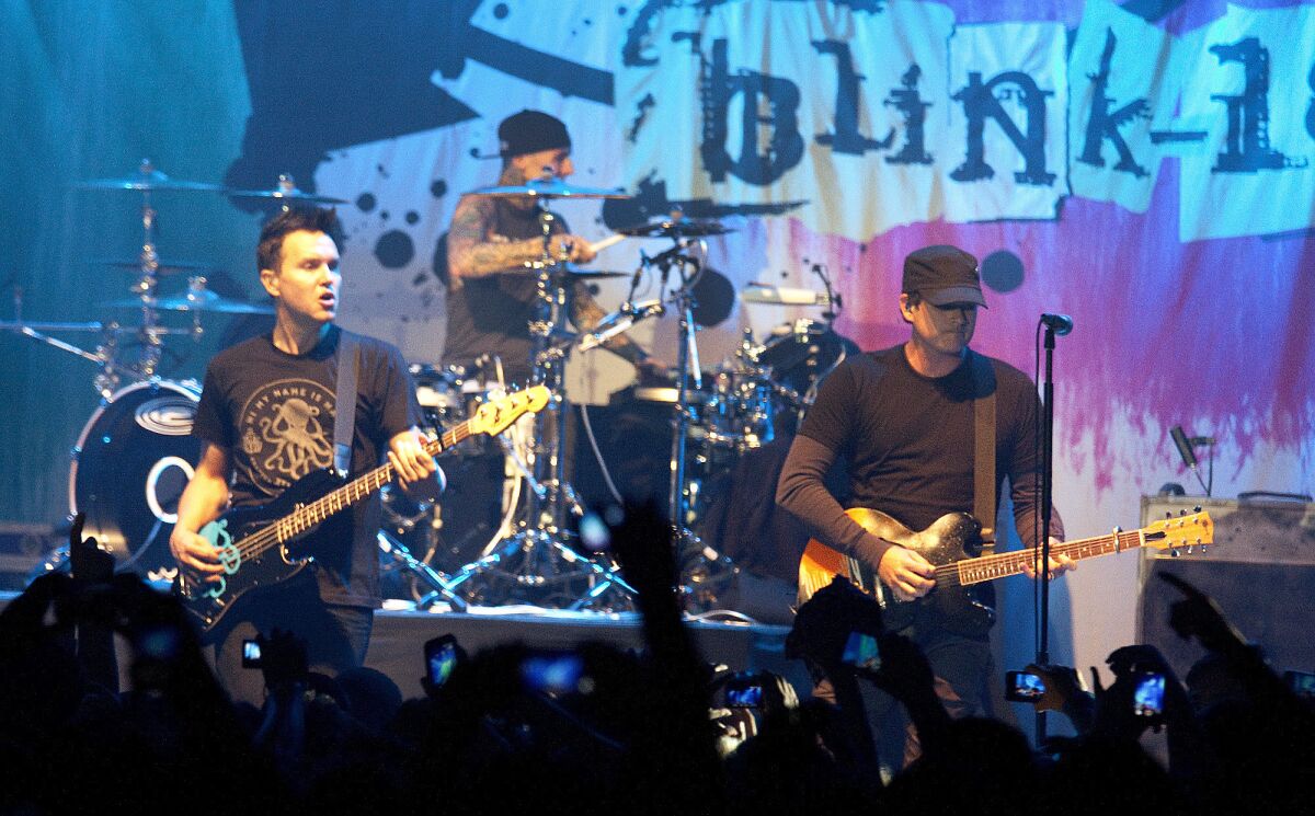 Mark Hoppus, left, Travis Barker and Tom DeLonge of Blink-182 perform at the Hollywood Palladium in 2013.