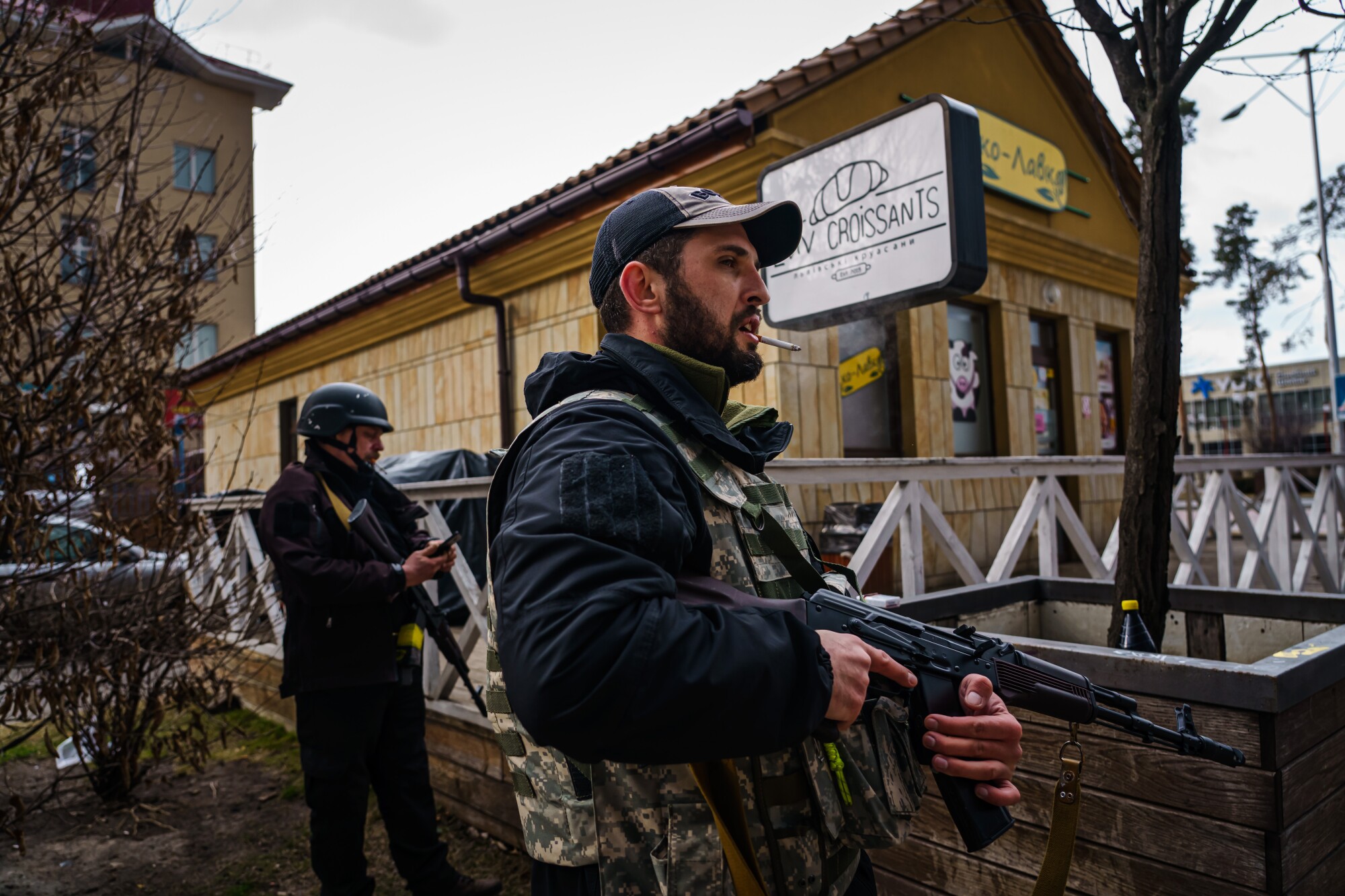 Ukrainian soldiers stand guard outside the train station in Irpin.