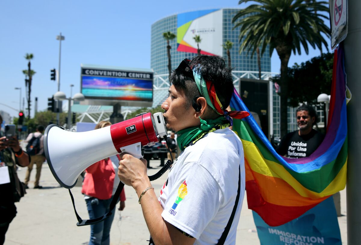Salvadorian activist Obbi Fenix speaks into a bullhorn at the 2022 Summit of the Americas.