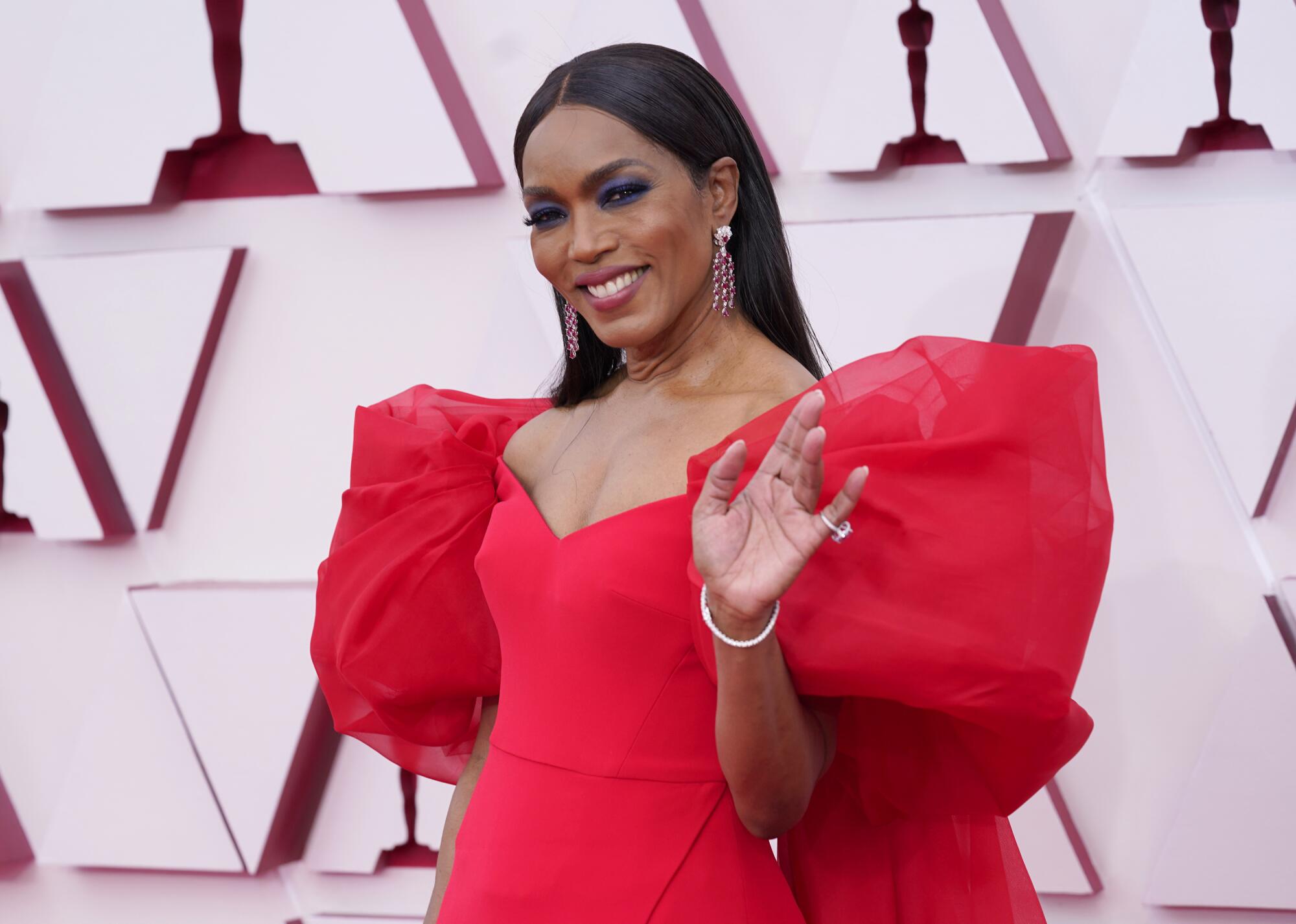 Angela Bassett wears a red dress with poufy sleeves
