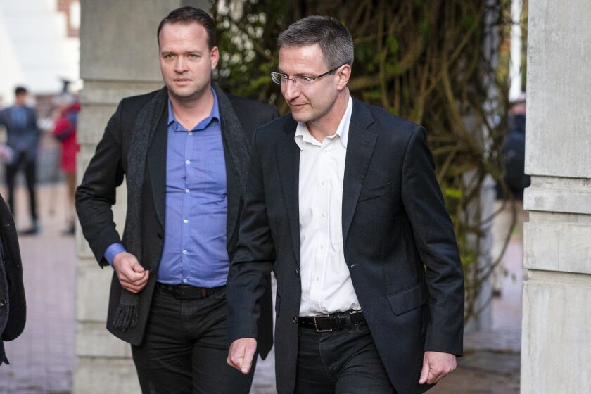 Bram ven der Kolk, letf, and Mathias Ortmann outside court after pleading guilty to their involvement in running the once wildly popular pirating website Megaupload in Auckland, New Zealand, Thursday, June 15, 2023. The pleas by Mathias Ortmann and Bram van der Kolk at the Auckland High Court ended their legal battle to avoid extradition to the U.S. on charges that included racketeering. (New Zealand Herald via AP)